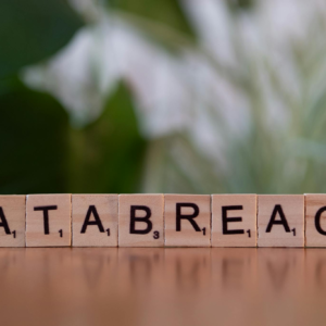 Close-up of Scrabble tiles spelling 'data breach' on a blurred background